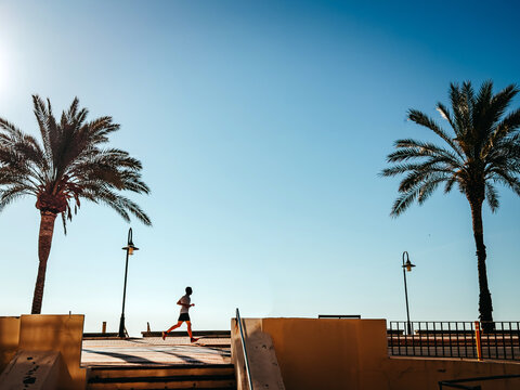 Alone runner on a summer seaside promenade