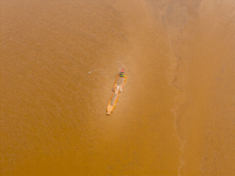 Aerial view of a barge carrying sand on the murky brown waters of the Napo River near Sani Lodge in El Retiro, Sucumbios, Ecuador.