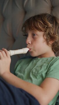 A little boy learns to play the flute at home, practicing with focus and enthusiasm in a cozy, warm setting. A charming scene of early musical exploration, creativity, and childhood growth.