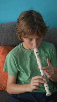 A little boy learns to play the flute at home, practicing with focus and enthusiasm in a cozy, warm setting. A charming scene of early musical exploration, creativity, and childhood growth.