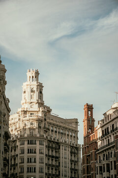 Vertical view of historic architecture and the main Correos building tower in Valencia, Spain. Warm daylight illuminating elegant classic facades under a clear sky with space for text.