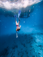 Female snorkeler swimming horizontally beneath the sea surface in clear blue water, leaving bubbles behind, with spacious underwater copy space for travel and vacation marketing. © JairoMZ