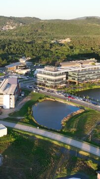 Artificial Lake Integrated with Modern Technology Buildings and Green Infrastructure in Florian&oacute;polis, Brazil. Establishing Shot. Aerial View.