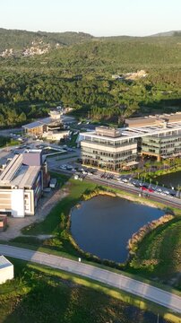Artificial Lake Integrated with Modern Technology Buildings and Green Infrastructure in Florian&oacute;polis, Brazil. Establishing Shot. Aerial View.
