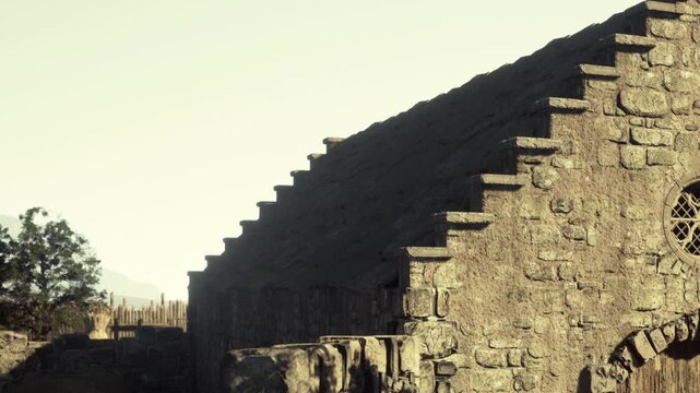 A stone structure stands under a clear sky. The edges of the roof are seen alongside trees. The building has features that suggest it is historical and significant.