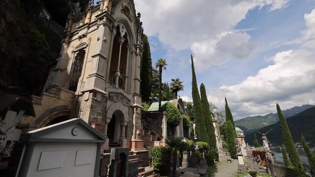 Morcote, Switzerland - 21 August 2026: View of the historic Monumental Cemetery overlooking Lake Lugano with ornate tombs, cypress trees, and mountain scenery.