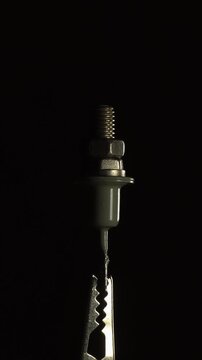 Metal power diode electronic component with threaded stud and electrical terminal against dark background.