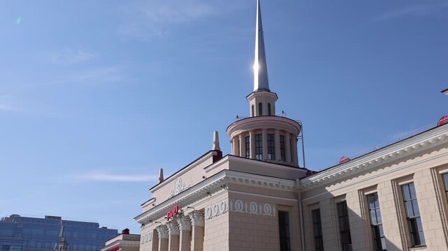 Petrozavodsk, Republic of Karelia, Russia - 19 August 2026: View of the historic Petrozavodsk Railway Station with neoclassical columns and tower, featuring buses and people on the plaza.