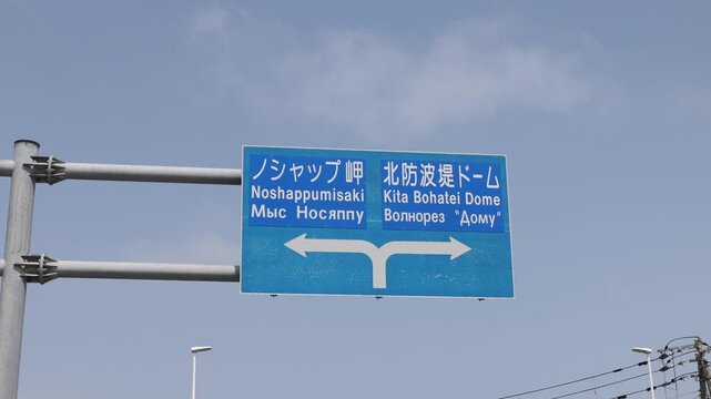 Wakkanai, Hokkaido, Japan - 19 August 2026: View of a blue road sign indicating directions to Noshappumisaki and Kita Bohatei Dome.