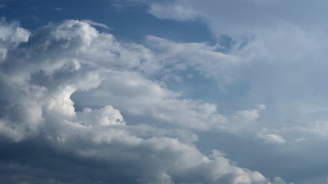 Timelapse of billowy cumulus and cumulonimbus clouds moving across sky