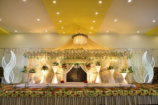 A image shows royal wedding stage setup featuring a luxury bed sitting for the traditional marriage event in India