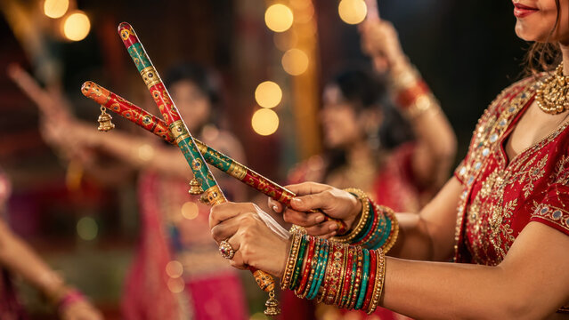Woman holding decorated dandiya sticks at garba dance celebration, navratri festival, traditional indian folk performance