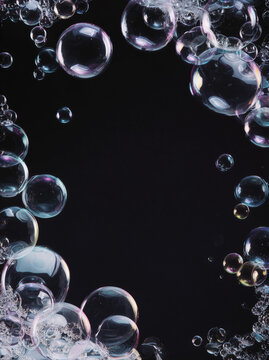Iridescent Soap Bubbles Framing Black Background With Space for Copy, Floating Transparent Spheres