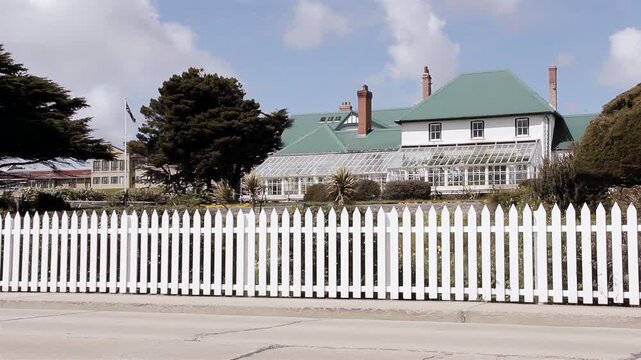 White SUV Driving Fast In Front Of Historic Government House In Port Stanley Falkland Islands (Islas Malvinas) - 4K