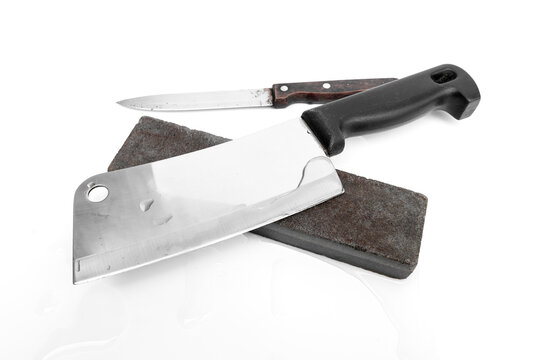 Essential tool for kitchen sharpening and knife care. Meat cleaver knife resting on a wet sharpening whetstone isolated on white background.