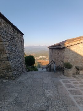 Cobblestone alley and stone houses leading to panoramic valley view in historic Mediterranean village