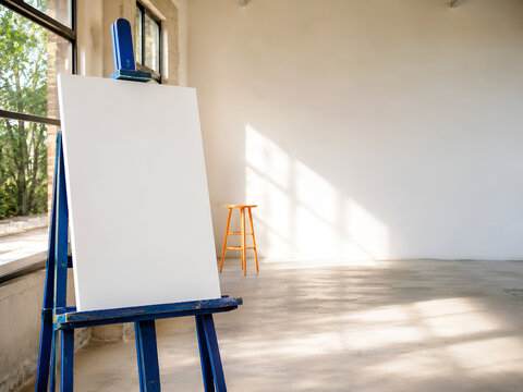Blank Canvas on a Blue Easel in a Sunlit Community Art Studio