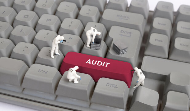 Miniature CSI forensic team investigating an audit key on computer keyboard, financial investigation and corporate fraud concept