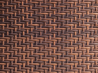 Synthetic rattan material creating a seamless interwoven pattern with contrasting shades of brown...