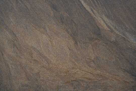 View of intricate patterns in the wet sand at Freshwater West, Wales, United Kingdom.