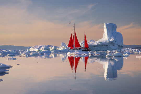 Red sailing boat in Ilulissat Icefjord in Greenland