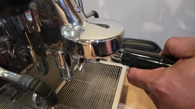 Hand tamping coffee grounds.