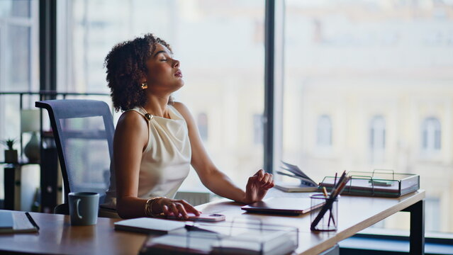 Businesswoman taking break office desk, relaxing eyes closed then working laptop