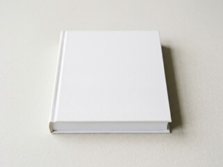Fototapeta premium Blank white hardcover book mockup lying on a neutral surface, top view, clean minimalist template for book cover design