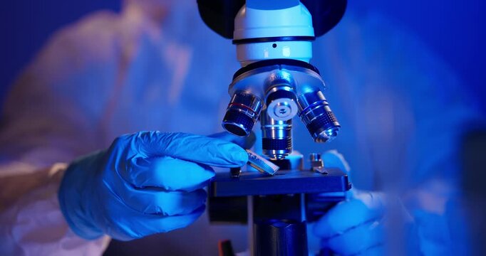 Laboratory artificial intelligence data center, Gloved hands use microscope for control quality of microprocessor semiconductor.