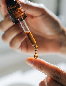 Detailed close up of a hand applying serum onto fingertip highlighting important steps in a skincare routine and showcasing essential beauty practices for healthy skin