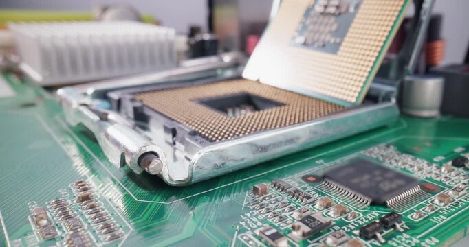 Closeup tracking shot of cpu processor being inserted into motherboard socket on electronics workbench, work service in data center.