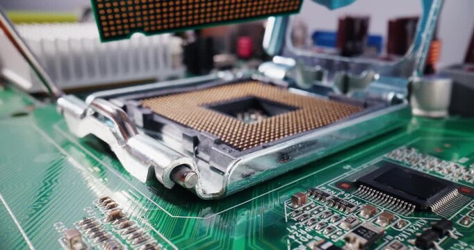 Macro probe tracking shot of technician worker installing cpu processor into motherboard socket inside desktop computer case.