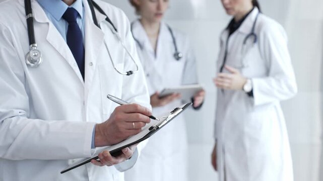 Medical professional writing on clipboard with stethoscope, a doctor and female assistant collaborating in a clinic, discussing patient data and healthcare information