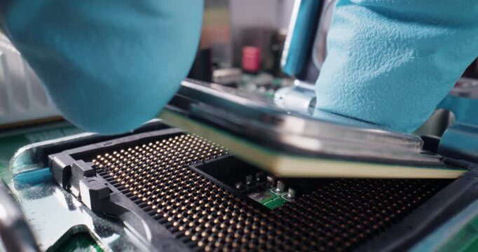 Slow motion technician placing AI cpu processor into motherboard socket on electronics bench in lab.