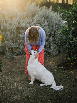 woman wearing a self made hand knit cardigan patting dog