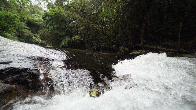 Cachoeira fluindo com &aacute;guas cristalinas em meio &agrave; floresta verde"