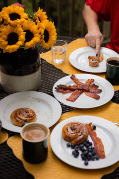 Outdoor Breakfast Table set with Coffee, bacon and cinnamon rolls