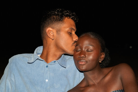 A couple enjoying a moment on the beach at night