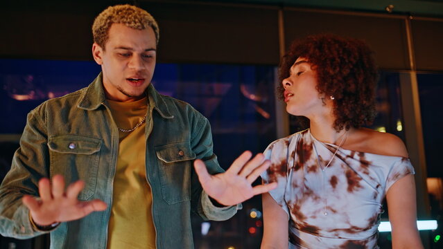 Young couple arguing evening apartment. Man woman gesturing during conflict