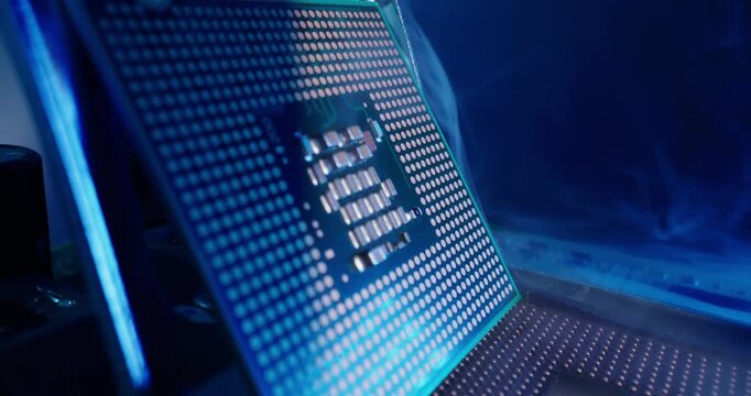 Tracking shot of AI computer processor being placed on motherboard in electronics lab with rising smoke and slight tilt.
