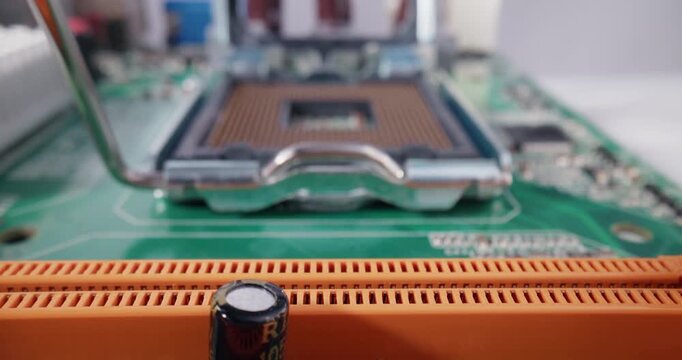 Slow motion insertion of cpu chip into motherboard socket on green pcb at electronics workbench with gloved hands, macro probe tracking shot.