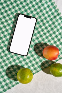 Smartphone Mockup on Green Gingham Tablecloth with Summer Fruit