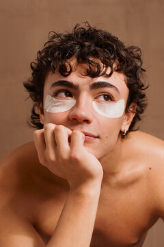 Young Man With Eye Patches Resting His Chin on His Hand