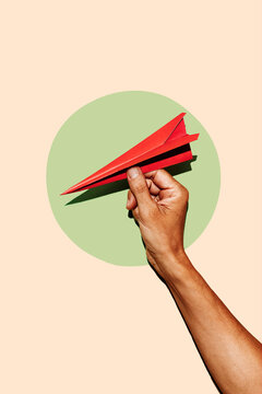 a man holds a vivid red paper airplane within a pale green circle