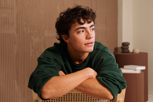Young Man Sitting on Chair in Indoor Space