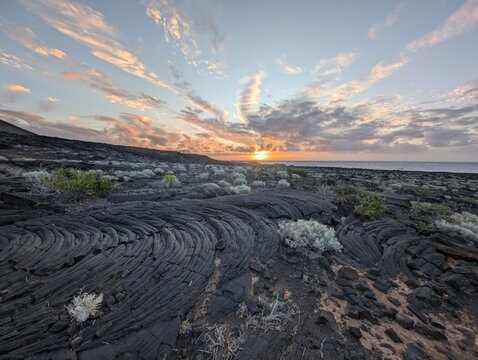 Sunset over volcanic lava field and ocean coast in El Hierro, Canary Islands
