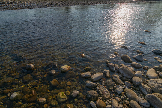 Murti river in the morning, riverbed in foreground with flowing water and stones. Scenic beauty of Dooars landscape, West Bengal, India