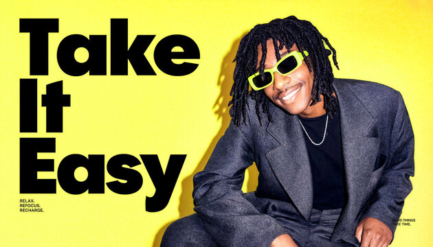 Poster with Take It Easy slogan and a smiling man in green sunglasses and a grey blazer against a yellow background.