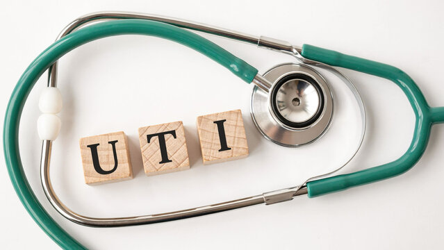 UTI word on wooden blocks with green stethoscope on white background
