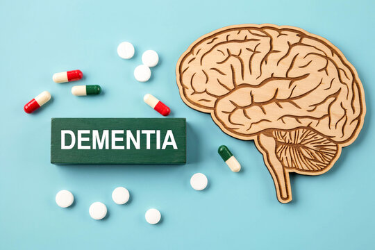 Dementia word block with wooden brain model and medicine pills